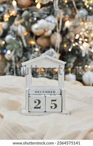 Vintage vintage calendar made of wood on the background of a Christmas tree. On the calendar, December 25, Christmas