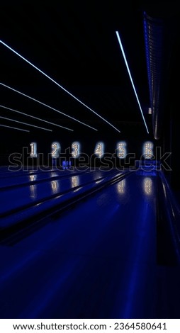 Bowling. Dark Playroom with Bowling Lanes. Six Bowling Alleys for Play with Blue Backlighting and Numbers. Vertical Shot.