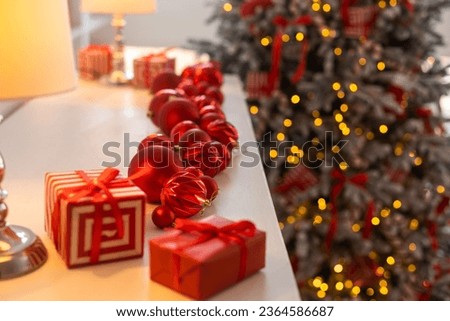 Beautiful Christmas gift boxes on floor near fir tree in room.