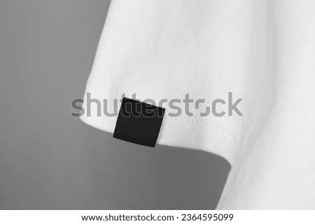 blank black color clothing label on white t shirt sleeve Royalty-Free Stock Photo #2364595099