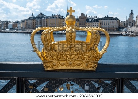 Stockholm, Sweden. Gilded Crown on Skeppsholmsbron Bridge closeup. Royal family symbol at Gamla Stan, Old Town, blue sky background.