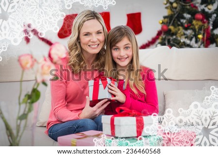 Festive mother and daughter with gift against snowflake frame