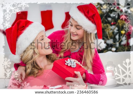 Festive mother and daughter with gift against christmas themed frame