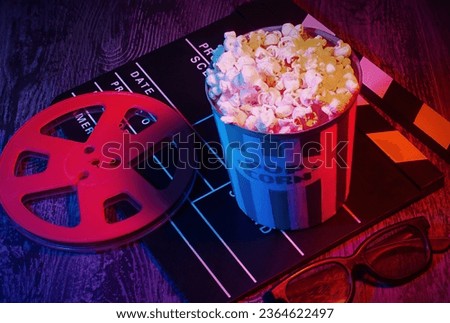Cinema movies concept background, with a pop corn bucket, 3D glasses. Movie night template, table top photography commercial shot, with a retro purple, aesthetic. Royalty-Free Stock Photo #2364622497