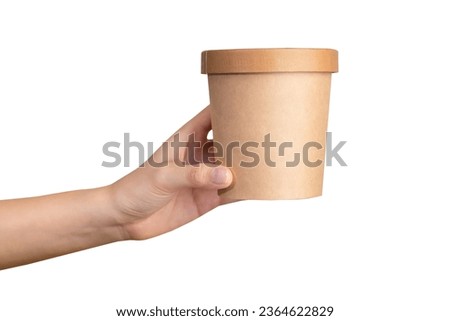 Clipping path, hand holds craft paper soup cup on isolated white background.