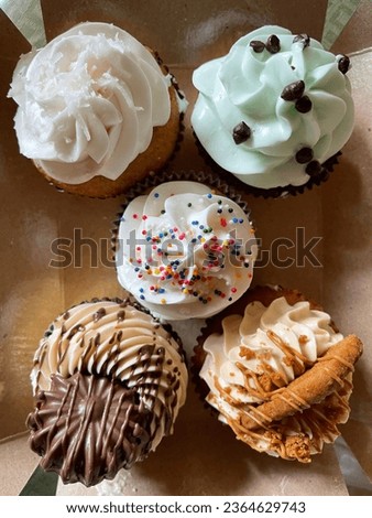 A picture of a cup cake decorated with sugar icing on a cardboard box background