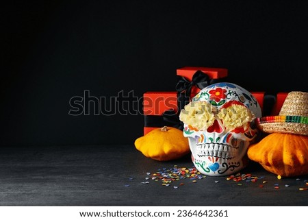 Mexican skull, sombrero, zucchini and gift boxes on black background, space for text