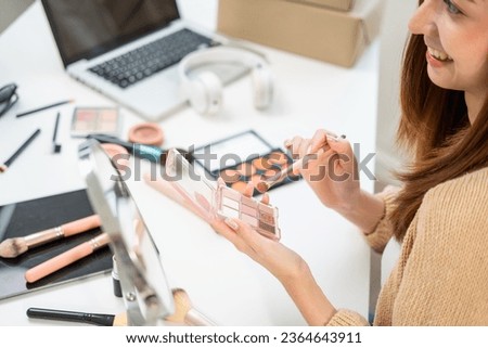 Young beautiful asian woman vlogger live broadcasting cosmetic makeup tutorial content with eye shadow. Influencers professional beauty make up with various cosmetics recording video on social media Royalty-Free Stock Photo #2364643911