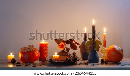 autumn dark decor with candles on wooden shelf on background wall