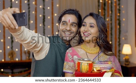 Smiling Indian couple taking selfie after Karwa Chauth celebrations - capturing memories. Newly wed couple capturing pictures after celebrating Karwa Chauth festival - dressed beautifully in tradit...