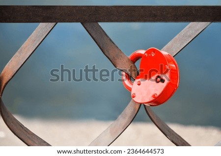 Red padlock in shape of heart on metal fence. padlock as symbol of love, engagement and wedding