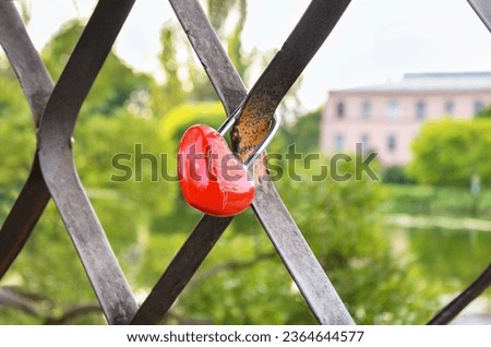 Red padlock in shape of heart on metal fence. padlock as symbol of love, engagement and wedding