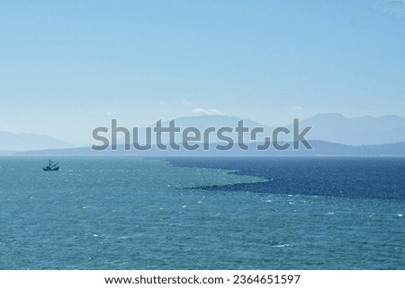 Fishing Trawler Crossing Changing Color Water Where Different Temperature of Currents Meet Royalty-Free Stock Photo #2364651597