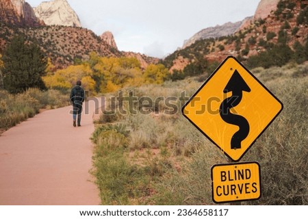 ''Blind curves'' sign table at Zion national park, man walking at national park, man traveller concept, autumn season national park  view, Utah, USA.