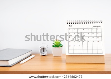 October 2023, Monthly desk calendar for 2023 year on wooden table with diary.