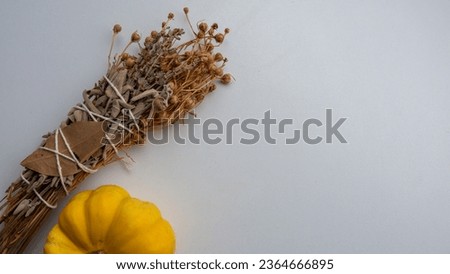 Picture of herbal incense made with herbs such as lavender and sage on a white background with a small ornamental pumpkin