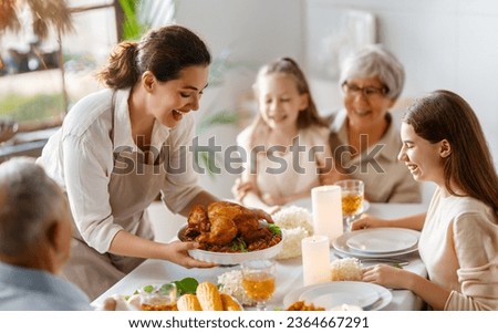 Thanksgiving Day, Autumn feast. Happy family sitting at the table and celebrating holiday. Grandparents, mother and children. Traditional dinner.