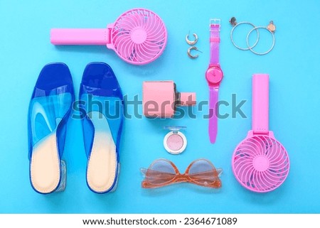 Composition with portable electric fans and stylish female accessories on blue background