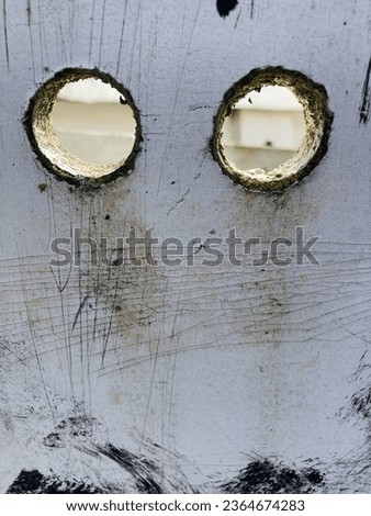 Round holes in a gray wooden board