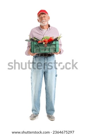 Mature male farmer with box of different ripe vegetables and FOR SALE sign isolated on white background
