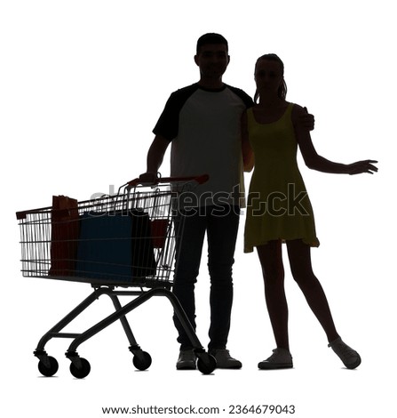 Silhouette of young couple with shopping cart on white background