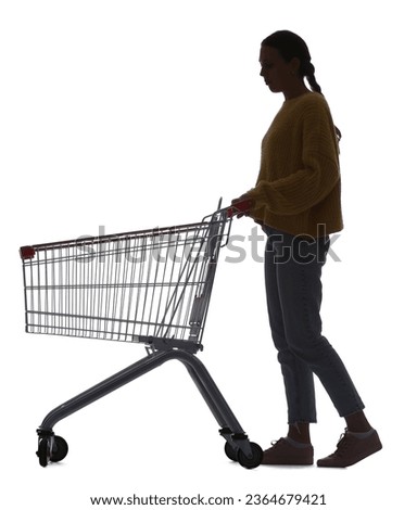 Silhouette of young woman with shopping cart on white background