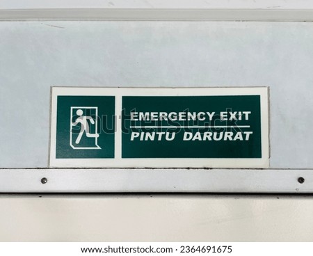 emergency exit posters or instructions posted above the emergency exit door as an evacuation direction in case of danger