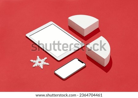 White blank screen digital tablet and smart phone mockup, template with white geometric shapes and snowflake shape Christmas ornament on red background