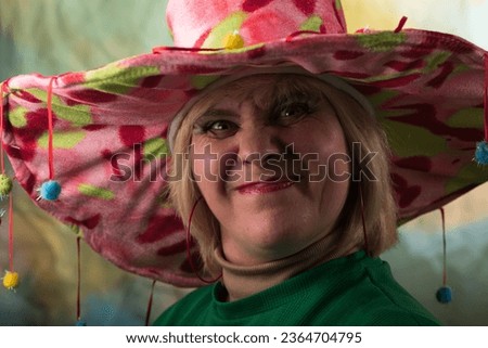 Funny photo of a man wearing makeup. Emotional character. Big eyes. Huge hat.