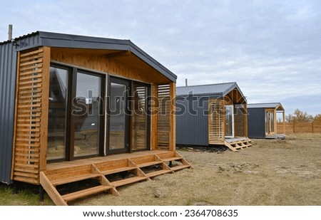Wooden houses in a triangular summer camp. summer vacation in an eco-friendly house, summer Royalty-Free Stock Photo #2364708635