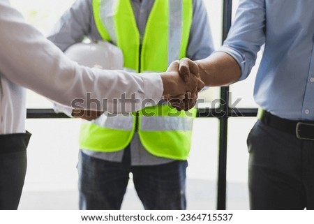 Collaboration of engineers, architects and contractors. Architects hand in hand promote teamwork cooperation of colleagues in construction projects.