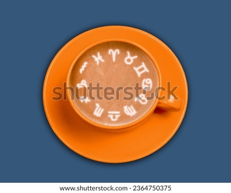 Top view coffee cup with horoscope signs made from milk foam on blue background. Astrology concept.