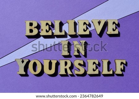 Believe in Yourself, words in wooden alphabet letters isolated on purple background as banner headline