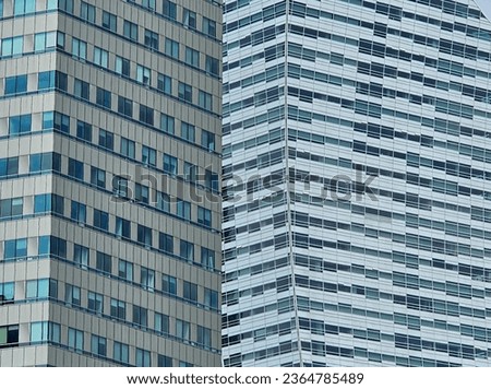 An abstract pattern created by the windows of two office buildings standing next to each other in the center of Warsaw on a sunny summer day, Warsaw, Poland.