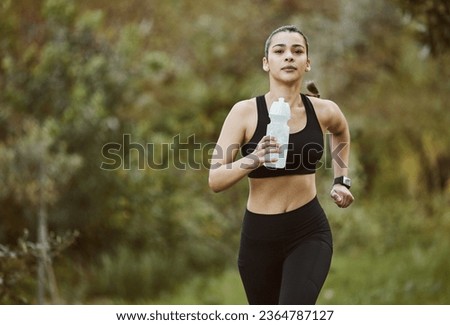 Woman, water bottle and running in nature for fitness, workout or outdoor exercise with hydration. Active person, athlete or runner and natural mineral drink for training, nutrition or sustainability Royalty-Free Stock Photo #2364787127