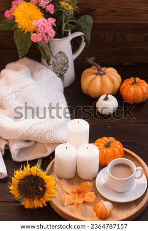 Autumn romantic evening, ripe pumpkins by candlelight. Bouquet of yellow autumn flowers