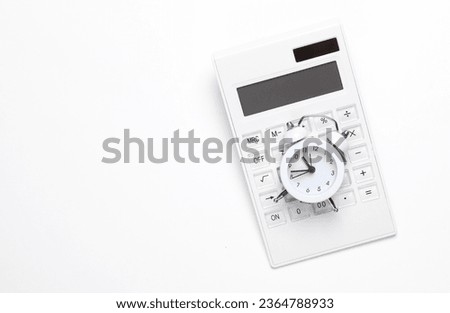Calculator with an alarm clock on a white background. Time is money. Business concept