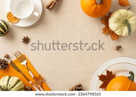 Rustic holiday table setup: Top view showcases plates, cup, napkin and cutlery, complemented by pumpkins, dried orange slice, acorns, and cinnamon sticks. Empty space for your text or advert Royalty-Free Stock Photo #2364798565