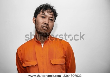 Prisoner in orange robe concept,Portrait of asian handsome man in Prison uniforms,Bandit has a lot of muscle, Royalty-Free Stock Photo #2364809033