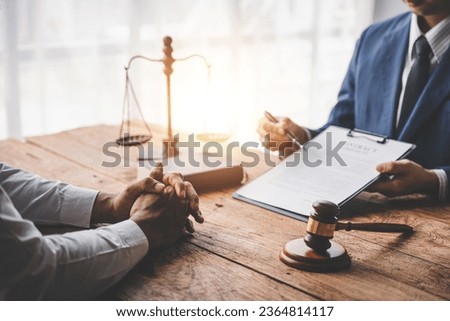 concept of justice and law A male judge in the courtroom on a wooden table and a male counselor or lawyer working in the office. Law, advice and justice concepts.