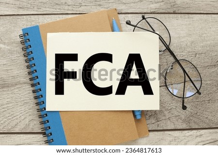 FCA - Financial Conduct Authority notebook with a blue stripe and glasses on the notebook.