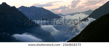 Sunset with a cloud inversion in the top of the Austrian Alps on the boarder with Italy. This shot was taken on night 4 of a 5 day hiking across the Zillertal mountain range Royalty-Free Stock Photo #2364818173
