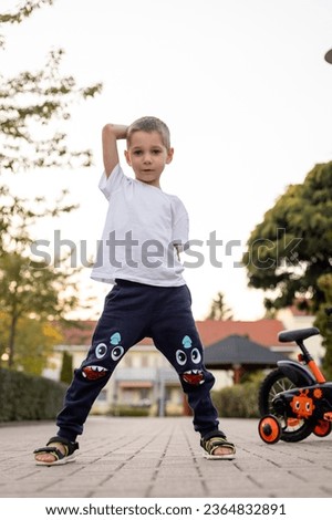 A boy stands near a bicycle on the street. School holidays, cycling. High quality photo