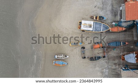 Aerial great view at empty fishermen boats during low tide on the sea, only sand, no water. Drone image from the top. 