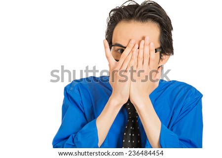 Closeup portrait young shy timid man covering face with hands with space to peek through isolated white background. Human emotion facial expression feelings, reaction life perception body language 