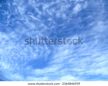 Wispy white cirrus clouds against a bright, sun-lit blue sky.  A warm summer’s day watching a county match at Trent Bridge cricket ground, Nottingham, UK.  June 2013. Royalty-Free Stock Photo #2364846939