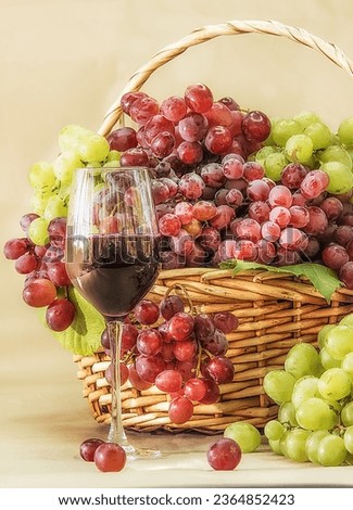 Ripe red grapes in a basket with a glass of juice. clear sunny autumn day