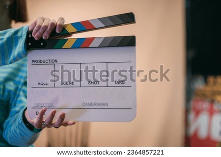Assistant director with clapperboard on set. Close-up of firecrackers for filming a movie, advertising, TV series. Modern photography technique. Royalty-Free Stock Photo #2364857221