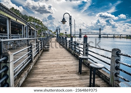 Riverwalk along the waterfront of the Cape Fear River overlooking Memorial Bridge Wilmington, NC Royalty-Free Stock Photo #2364869375