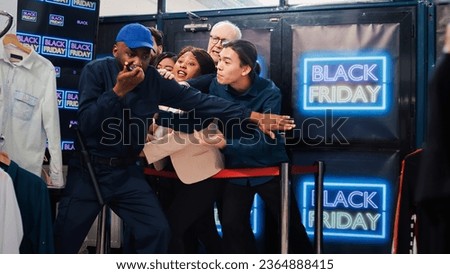 Black friday shoppers argue at entrance to catch promotional prices on clearance items, angry people eager to start shopping. Mall customers pushing security man, asking him to open store. Royalty-Free Stock Photo #2364888415